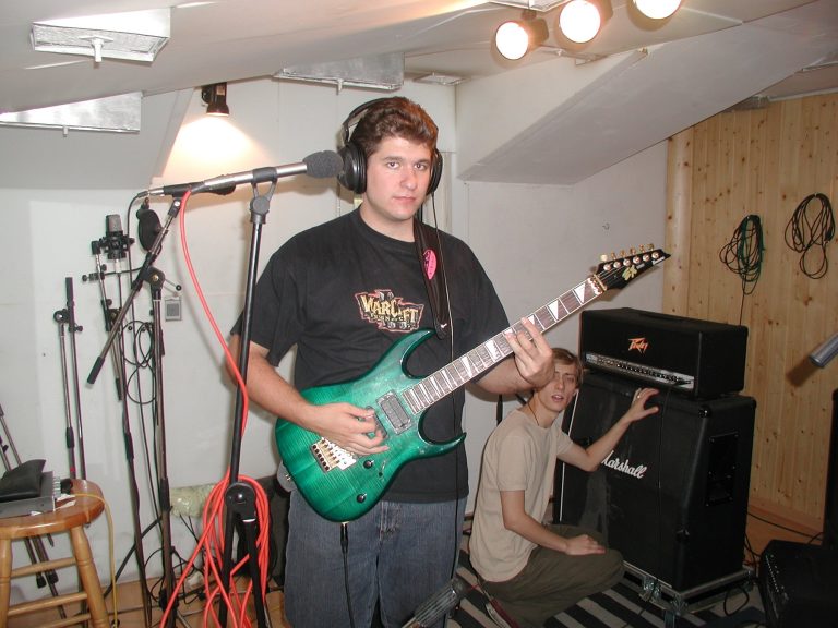 Alexander Pfeiffer spielt im Aufnahmeraum eine grüne E-Gitarre; im Hintergrund steht ein Bandmitglied am Marshall-Verstärker.