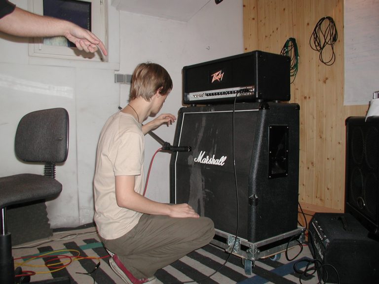 Ein Bandmitglied stellt im Aufnahmeraum den Marshall-Gitarrenverstärker ein.