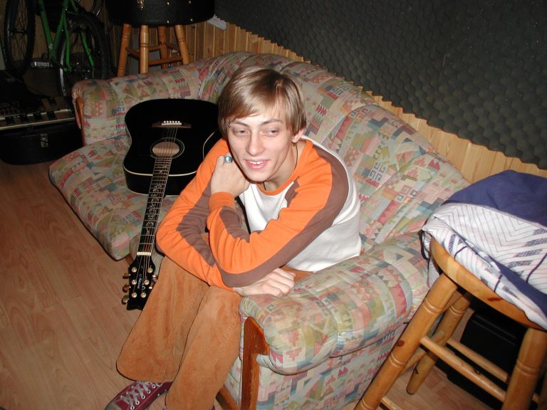 Ein Bandmitglied sitzt während einer Aufnahmepause auf dem Studiosofa.