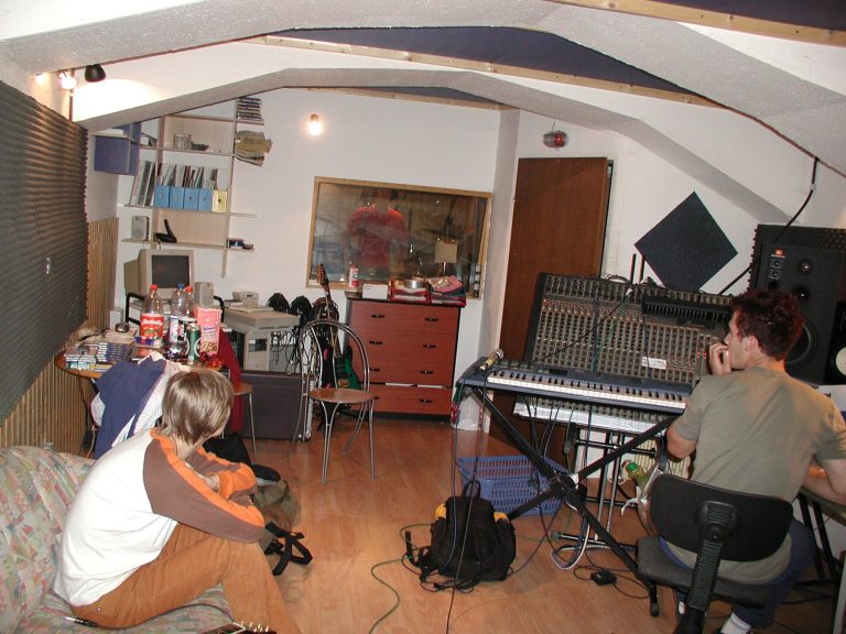 Bandmitglieder und Instrumente füllen den Regieraum des Tonstudios.