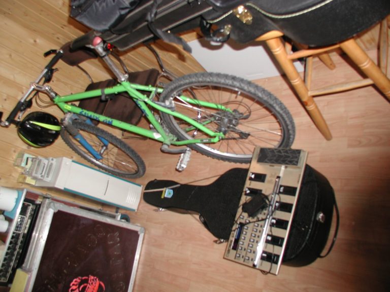 Effektpedale, Instrumente, Kabel und ein Fahrrad liegen und stehen im Aufnahmeraum.